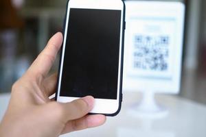 las manos usan el teléfono para escanear códigos qr para recibir descuentos en compras. foto