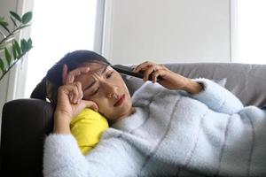 The sick woman lying on the couch had anxious facial expression, disappointment and sad after receiving bad news on the phone. photo