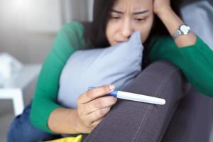 las mujeres asiáticas tienen expresiones faciales ansiosas y piensan en los resultados de las pruebas de embarazo no deseado.
