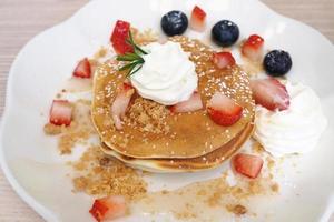Pancakes sprinkled with strawberries and blueberries photo