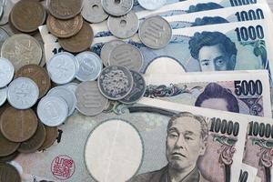 billetes de yen japonés y monedas de yen japonés por concepto de fondo de dinero foto