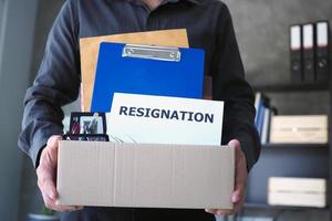 Businessman hold boxes for personal belongings and resignation letters. photo