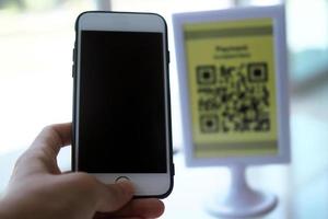 Hands use the phone to scan QR codes to receive discounts on purchases. photo