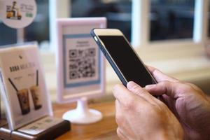 Hands use the phone to scan QR codes to accumulate points in restaurants. photo