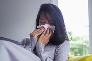 las mujeres asiáticas tienen fiebre alta y secreción nasal. concepto de personas enfermas foto