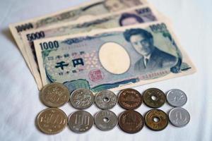 billetes de yen japonés y monedas de yen japonés por concepto de fondo de dinero foto