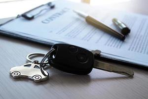 Car keys placed on contract documents about car loans. photo