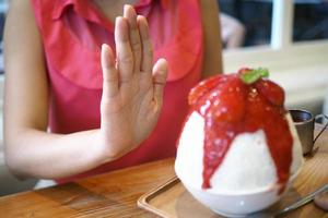 las mujeres empujan la copa de helado. se negaba a comer todo tipo de dulces. evitar el azúcar y los dulces para una buena salud. concepto de dieta foto