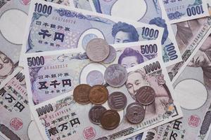 moneda japonesa. hay un montón de billetes de banco y monedas. intercambiar con bienes y servicios y utilizar para cancelar deuda localmente o en una determinada empresa socioeconómica de acuerdo a la ley. foto