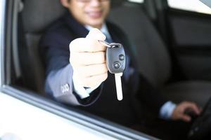 The car salesman and the key to the new owner. photo