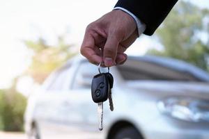 The car owner is standing the car keys to the buyer. Used car sales     The car owner is standing the car keys to the buyer. Used car sales photo