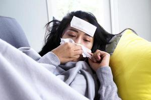 las mujeres asiáticas tienen fiebre alta y secreción nasal. concepto de personas enfermas foto