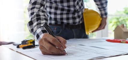 The work desk of the project contractor or engineer viewing the building structure plan photo