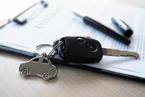 Car keys placed on contract documents about car loans. photo