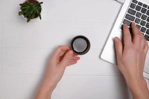 Laptop on workplace, female hands, top view, copy space photo