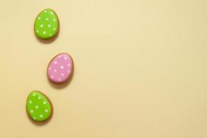 Happy easter. Pastel colors Easter eggs with cookies on beige background. photo