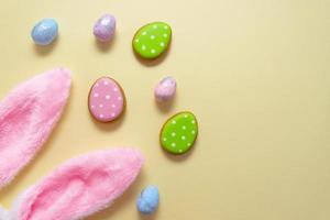 Happy easter. Pastel colors Easter eggs with cookies on beige background. photo