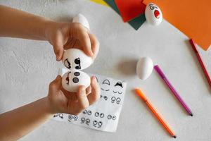 children decorate dummies of white eggs, stick stickers with different emotions, study of emotions photo