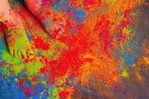 children's feet all sprinkled with multi-colored bright Holi colors, copy space. Indian festival of colors Holi. photo