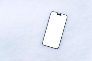 Phone in snow with isolated display in white color for mockup, app design presentation photo