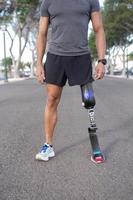 Crop sportsman with leg prosthesis standing on street photo