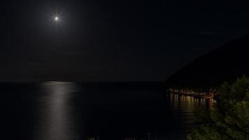 time-lapse video van de maan passage over- de zee met fascinerend reflecties in de water