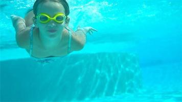 Adorable little girl in the swimming pool underwater