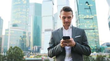 Young caucasian man holding smartphone for business work. video