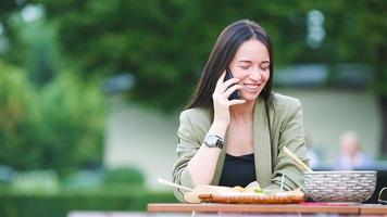 jonge vrouw die op straat meeneemnoedels eet? video