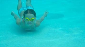 la petite fille dans la piscine sous l'eau et souriante video