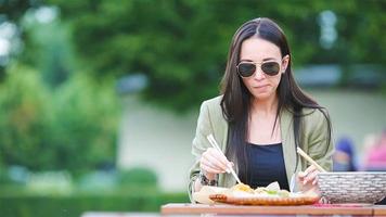 jonge vrouw die op straat meeneemnoedels eet? video