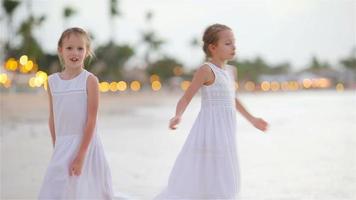 Entzückende kleine Mädchen haben viel Spaß am Strand. zwei schöne Kinder sind glücklich video