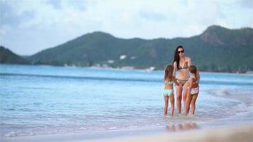 schöne Mutter und ihre entzückenden kleinen Töchter am Strand