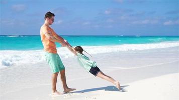 Little girl and young father having fun during tropical beach vacation. SLOW MOTION video