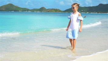 adorable petite fille sur la plage sur l'île des caraïbes. video