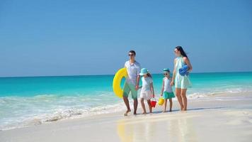 Happy beautiful family of four on a tropical beach vacation video