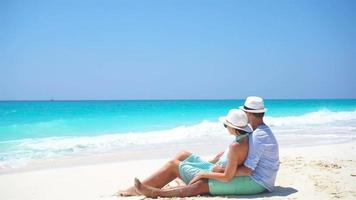 jeune couple sur la plage blanche pendant les vacances d'été. les amoureux heureux profitent de leur lune de miel. video