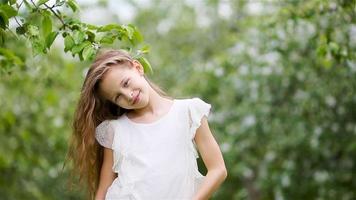 adorable petite fille dans un jardin de pommiers en fleurs le beau jour du printemps video