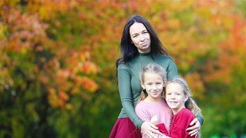 Family of mom and kids in fall. Young mother and little girls enjoy warm autumn video