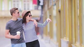 romantisch paar wandelen samen in Europa. gelukkig geliefden genieten van stadsgezicht met beroemd oriëntatiepunten. elegant stedelijk jong Mens met heet koffie en vrouw in hoed Aan reizen in Praag video