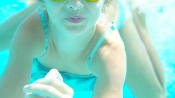 aanbiddelijk weinig meisje in de zwemmen zwembad onderwater- video