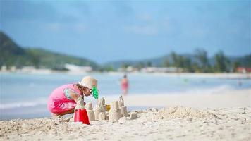 adorabile poco ragazza giocando con giocattoli su spiaggia vacanza. ragazzo fabbricazione un' sabbia castello su il riva del mare video