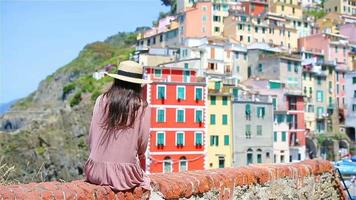 jeune femme avec une vue magnifique sur le vieux village de riomaggiore, cinque terre, ligurie, italie. vacances italiennes européennes. video