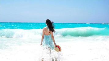 hermosa mujer sonriendo feliz en vacaciones de verano en playa blanca. niña feliz caminando en vestido de verano. camara lenta
