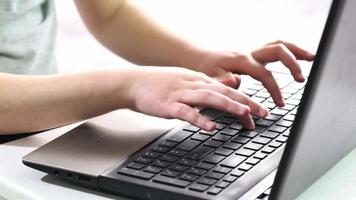 Hands of child on computer keyboard. Close up video