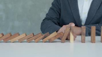 insurance with hands protect domino. Businessman hands stop dominoes falling in business crisis. business risk control and planning and strategies to run prevent insurance businesses. video