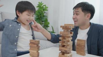 Aisa Happy single father playing learning games janga with the little boy. Funny family is happy and excited in the house. Father and son having fun spending time together. holiday, weekend, vacant. video