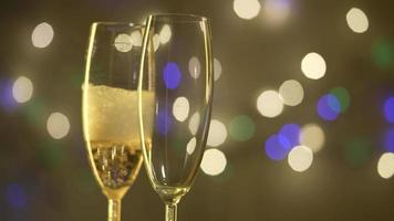 champanhe é derramado em copos, fundo de natal. câmera lenta. video