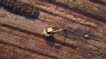 grävmaskin gräv jord på konstruktion webbplats. antenn se av en hjul lastare grävmaskin med en traktor läser in sand in i en tung jordflyttare. grävmaskin grävning jord gropar för de jordbruks industri. video
