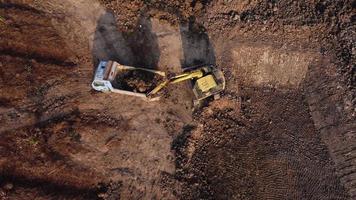 vista aérea de una excavadora de ruedas con una retroexcavadora cargando arena en una excavadora pesada en un sitio de construcción. Excavadora cavando pozos de suelo para la industria agrícola.